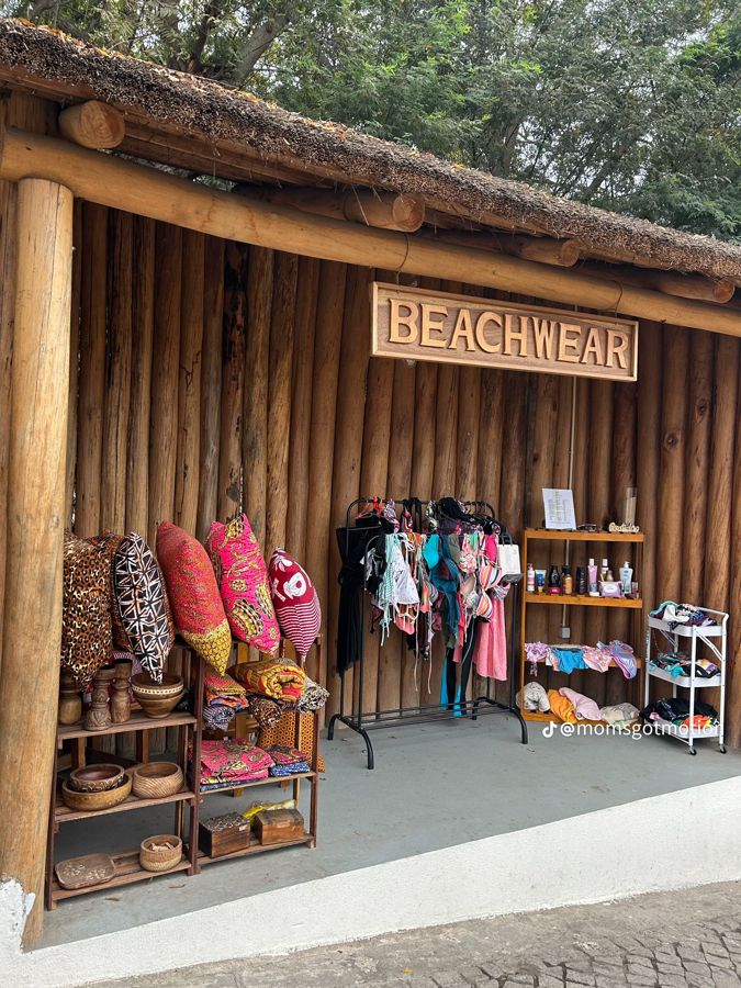 Loja Beachwear com almofadas de capulana, fatos de banho e peças em madeira